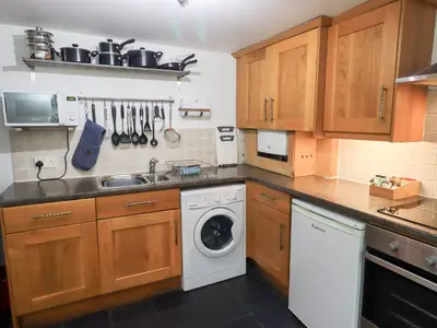 a kitchen with a sink and a washing machine at Kiln How in Keswick