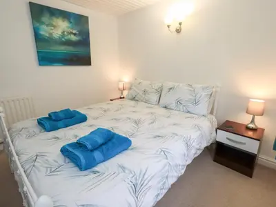 a bedroom with a bed with blue pillows on it at Kiln How in Keswick