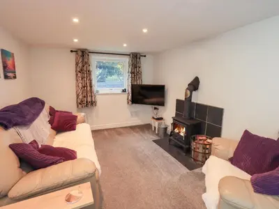 a living room with two couches and a fireplace at Kiln How in Keswick