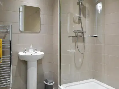 a bathroom with a sink and a shower at Holly Cottage in Cockermouth