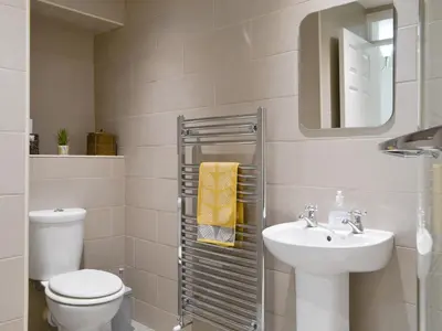 a bathroom with a sink and a toilet and a mirror at Holly Cottage in Cockermouth