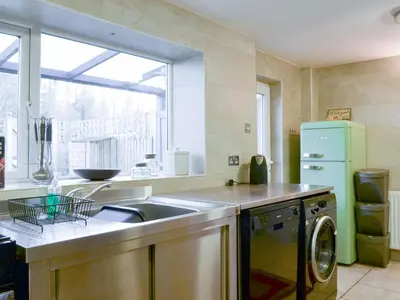 a kitchen with a sink and a refrigerator at Holly Cottage in Cockermouth