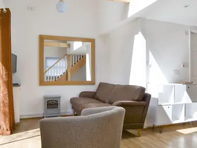a living room with a couch and a mirror at Langdale Cottage in Chapel Stile