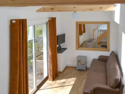 a living room with a couch and a mirror at Langdale Cottage in Chapel Stile
