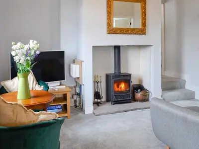 a living room with a fireplace and a television at Old Reading Room in Cotehill