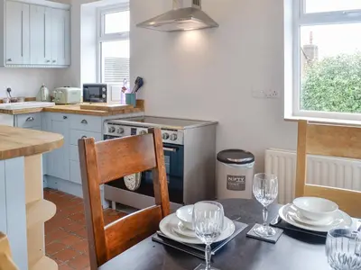 a kitchen with a table with plates and glasses on it at Old Reading Room in Cotehill