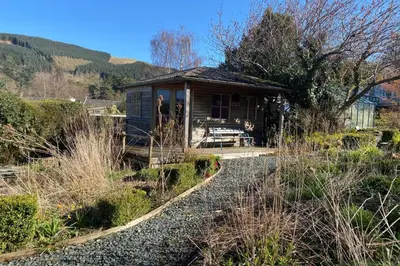 a tiny house in a garden with a gravel path at The Lookout Keswick in Keswick