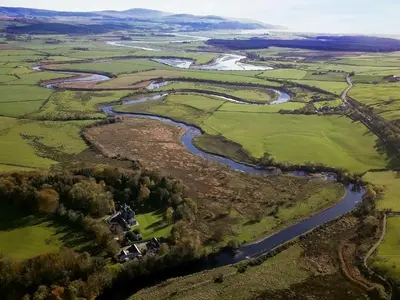 an aerial view of a river and fields at Machermore Castle in Newton Stewart