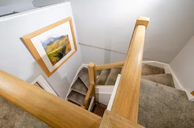 a staircase in a house with a painting on the wall at Cherry Tree Cottage in Chapel Stile