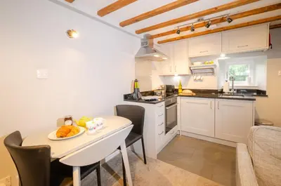 a kitchen with a table with a plate of food on it at Cherry Tree Cottage in Chapel Stile