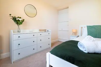 a bedroom with a bed with a white dresser and a mirror at Meadow View Chapel Stile in Chapel Stile