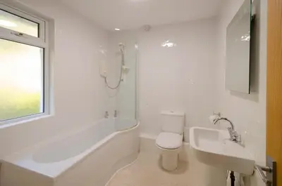 a bathroom with a tub and a toilet and a sink at 12 Thrang Brow, Chapel Stile in Chapel Stile