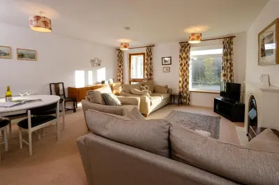 a living room with a couch and a dining room at 12 Thrang Brow, Chapel Stile in Chapel Stile