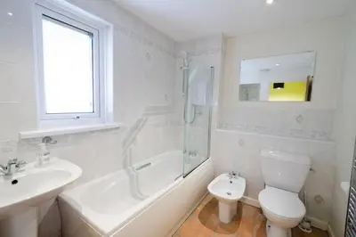 a white bathroom with a sink and a toilet at 27 Thrang Brow, Chapel Stile in Chapel Stile