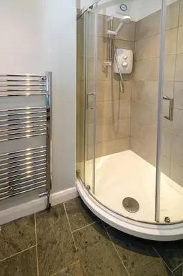 a shower with a glass door in a bathroom at Beck Steps, Elterwater in Chapel Stile