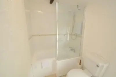 a white bathroom with a shower and a toilet at Inglewood Cottage, Chapel Stile in Chapel Stile