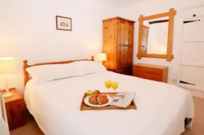 a bed with a tray with a plate of food on it at Inglewood Cottage, Chapel Stile in Chapel Stile
