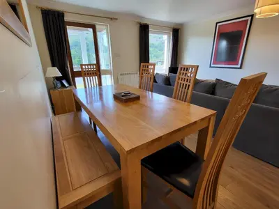 a wooden dining room table with chairs and a couch at Lingmell Fell View, Chapel Stile in Chapel Stile