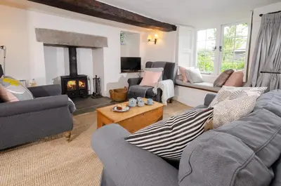 a living room with couches and a fireplace at Priest End, Chapel Stile in Chapel Stile