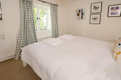 a white bed in a room with a window at Priest End, Chapel Stile in Chapel Stile