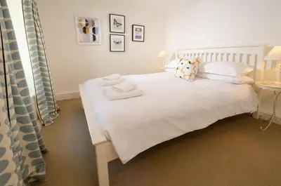 a bedroom with a white bed with two towels on it at Priest End, Chapel Stile in Chapel Stile