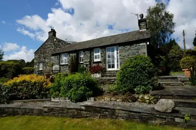 an old stone house with a garden in front of it at Rosegate Cottage, Elterwater in Elterwater