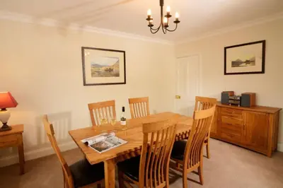 a dining room with a wooden table and chairs at Rosegate House, Elterwater in Elterwater