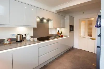 a white kitchen with white cabinets and a sink at Rosegate House, Elterwater in Elterwater