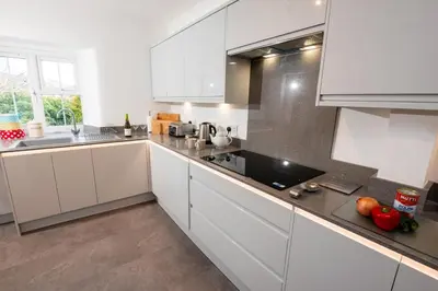 a white kitchen with white cabinets and a sink at Rosegate House, Elterwater in Elterwater