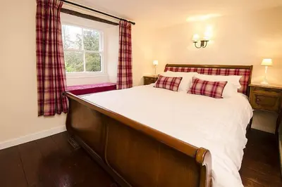 a bedroom with a large bed and a window at Speddy Cottage, Chapel Stile in Chapel Stile