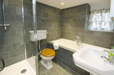 a bathroom with a toilet with a wooden toilet seat at Speddy Cottage, Chapel Stile in Chapel Stile