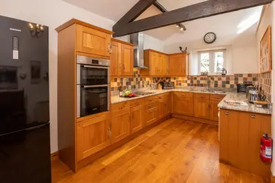 a large kitchen with wooden cabinets and wooden floors at Stickle Cottage, Great Langdale in Grasmere