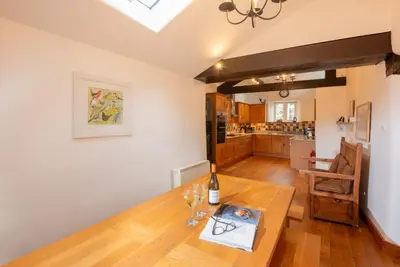a dining room with a table and a bottle of wine at Stickle Cottage, Great Langdale in Grasmere