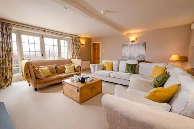 a living room with two couches and a table at The Eltermere Old Barn, Elterwater in Elterwater