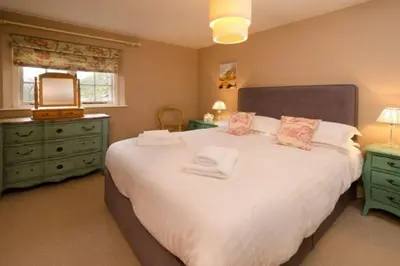 a bedroom with a large white bed and a window at The Eltermere Old Barn, Elterwater in Elterwater
