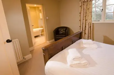 a bedroom with a bed with two towels on it at The Eltermere Old Barn, Elterwater in Elterwater