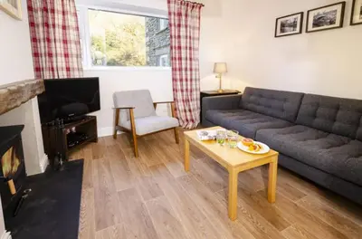 a living room with a couch and a table at The Old Post Office, Chapel Stile in Chapel Stile