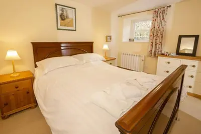 a bedroom with a large white bed and a window at The Old Post Office, Chapel Stile in Chapel Stile