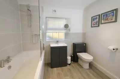 a bathroom with a tub and a toilet and a sink at The Old Post Office, Chapel Stile in Chapel Stile