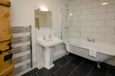 a bathroom with a tub and a sink and a bath tub at The Old White Lion, Chapel Stile in Chapel Stile