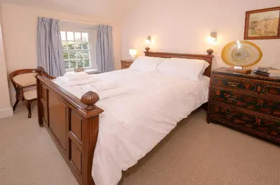 a bedroom with a large bed with a dresser and a window at The Old White Lion, Chapel Stile in Chapel Stile