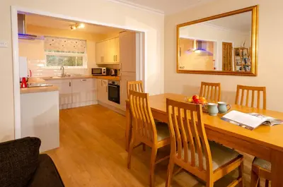 a kitchen and dining room with a wooden table and chairs at Underthrang, Chapel Stile in Chapel Stile