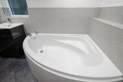 a white bath tub in a bathroom with a sink at Underthrang, Chapel Stile in Chapel Stile