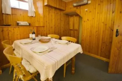 a dining room with a table and yellow chairs at Langstrath, Chapel Stile in Chapel Stile