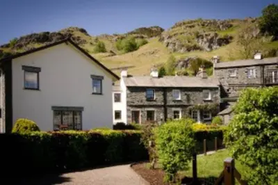 a large house with a hill in the background at Langstrath, Chapel Stile in Chapel Stile