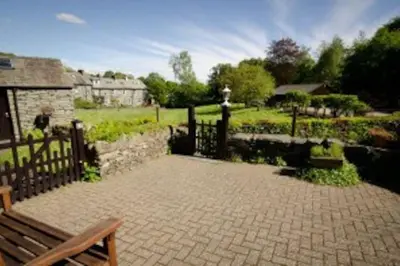 a park with a fence and a bench and a garden at Langstrath, Chapel Stile in Chapel Stile