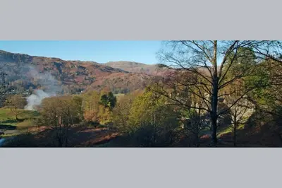 two pictures of a valley with trees and a mountain at Woodland Crag Cottage, Grasmere in Grasmere