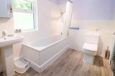 a white bathroom with a tub and a toilet and a sink at Jadians Nook, 16 Thrang Brow in Chapel Stile