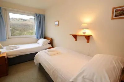 a hotel room with two beds and a window at Jadians Nook, 16 Thrang Brow in Chapel Stile