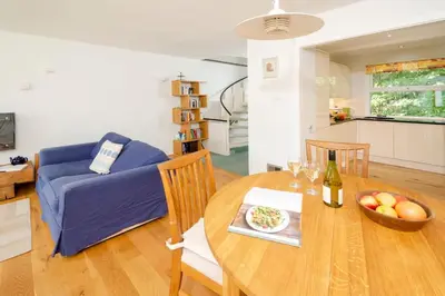a dining room table with a bowl of fruit and a bottle of wine at Jadians Nook, 16 Thrang Brow in Chapel Stile